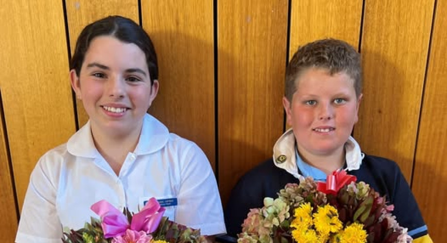 Photo of two St Johns Lutheran Primary School students holding wreaths prepared for ANZAC Day 2025.
