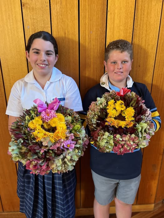 Photo of two St Johns Lutheran Primary School students holding wreaths prepared for ANZAC Day 2025.